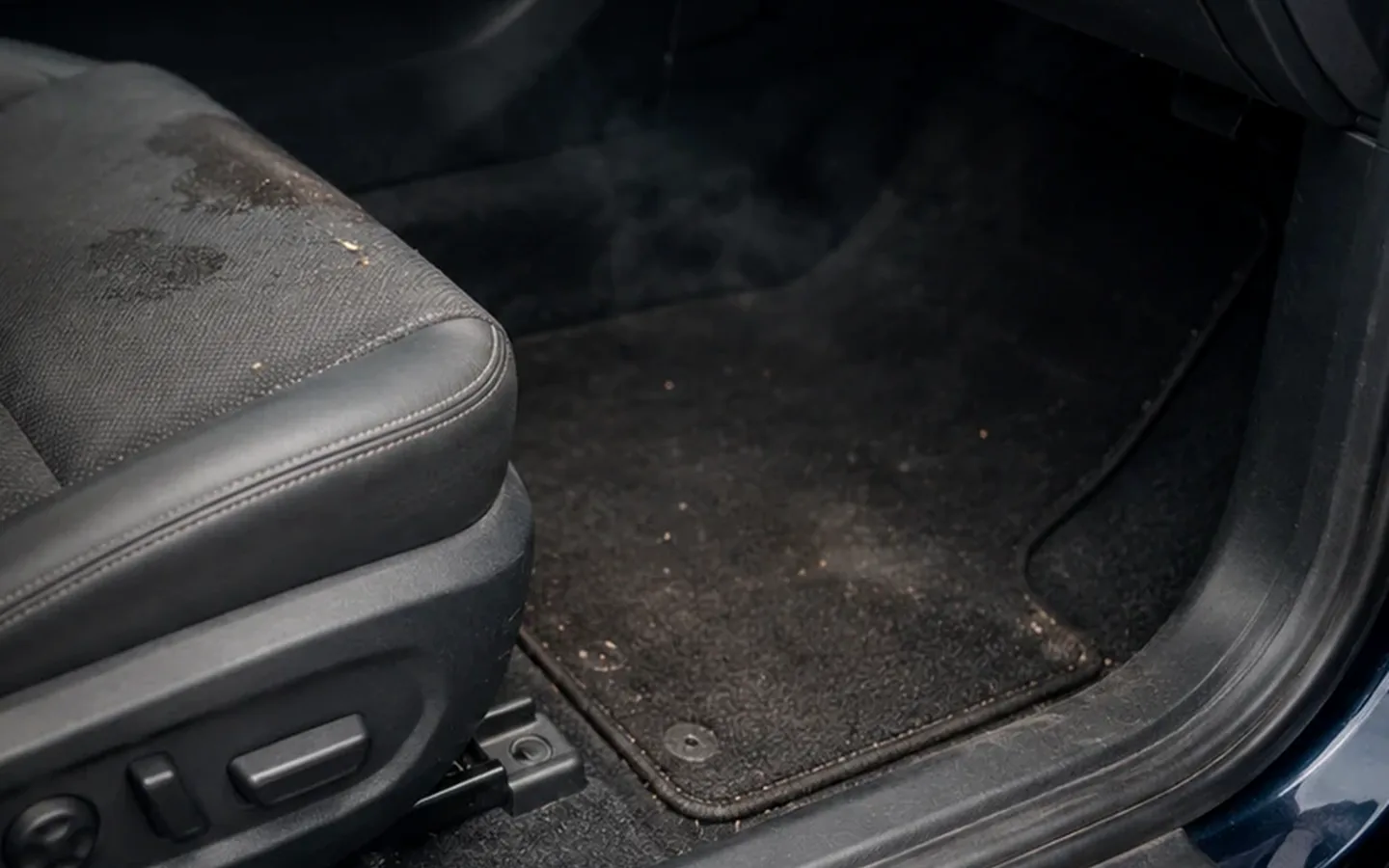 Interior de auto con suciedad y manchas que pueden originar malos olores